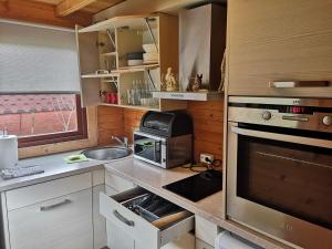 cocina con fregadero y fogones horno superior en Family Summer House in Jurmala, en Jūrmala