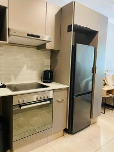 una cucina con piano cottura e frigorifero di Executive Studio Apartment in Sandton a Johannesburg