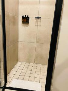 una ducha con 3 botellas en la pared en el baño en Executive Studio Apartment in Sandton, en Johannesburgo