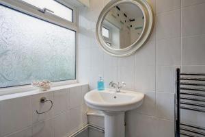 a white bathroom with a sink and a mirror at Sunny View by Winterton Cottages in Winterton-on-Sea +18 photos