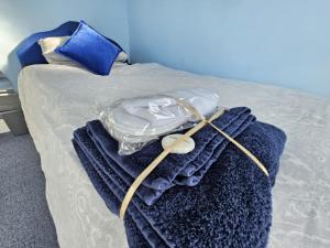 a bed with blue towels on it with a hanger at Single Unique Room For Professionals in Ealing