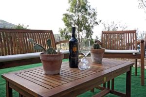 Una botella de vino sentada en una mesa de madera con cactus en Ferienhaus für 5 Personen ca 80 qm in Scopello, Sizilien Nordküste von Sizilien, en Scopello