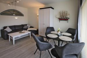 a living room with a couch and a table and chairs at Gro_e Stra_e 19_ Whg_ 1 in Wyk auf Föhr