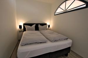- une chambre avec un lit doté de draps blancs et une fenêtre dans l'établissement Gro_e Stra_e 19_ Whg_ 1, à Wyk auf Föhr
