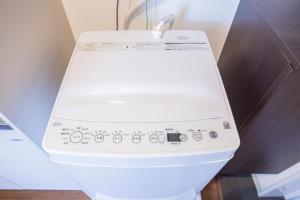 a white toilet with the lid up in a bathroom at Walk to Nishi-Nippori/Sendagi/Nippori sta. DBoY in Tokyo