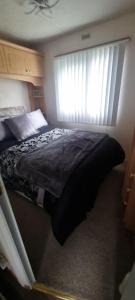 a bedroom with a large bed with a window at Three Peaks View. in Clitheroe