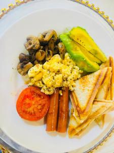 a plate of breakfast food with eggs sausage and vegetables at Eliza Guest House in Empangeni