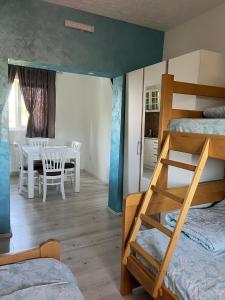 a bedroom with bunk beds and a dining room with a table at Apartments Vila Selena - Golija in Rudno