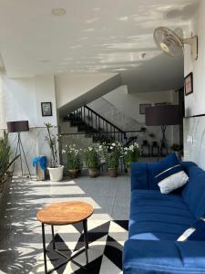 a living room with a blue couch and a table at Gallivanto Inn in New Delhi