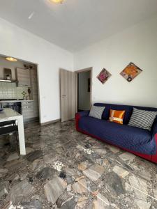 a living room with a blue couch and a kitchen at Loano Mare in Loano