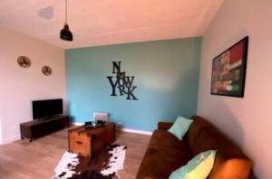 a living room with a couch and a tv at Studio New-York à Old School à l'ile d'yeu in Port-Joinville