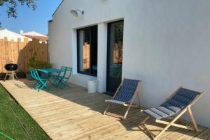 two chairs and a table on a wooden deck at Studio New-York à Old School à l'ile d'yeu in Port-Joinville
