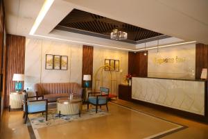 een lobby met een bank en een tafel en stoelen bij Freesia By Express Inn in Pālghar
