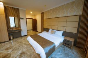 1 dormitorio con 1 cama grande en una habitación de hotel en Sarok Hotel, en Duhok