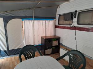 um quarto com duas cadeiras e uma mesa numa caravana em Camping Valle del Andarax em Fondón