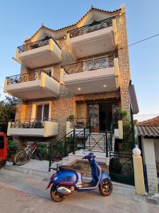 a blue scooter parked in front of a building at Porto Xronia in Khronia