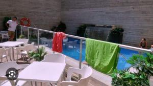 a balcony with white tables and chairs and a pool at ALBERGUE CASA MARIELA solo peregrinos con credenciales in Torres del Río