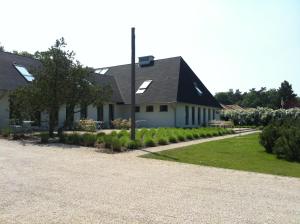 ein weißes Haus mit einem schwarzen Dach und einer Auffahrt in der Unterkunft Haus Dohrmann in Binz