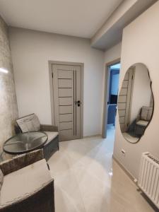 ein Wohnzimmer mit einem Spiegel und einem Tisch in der Unterkunft Chisinau Central Apartments in Chişinău