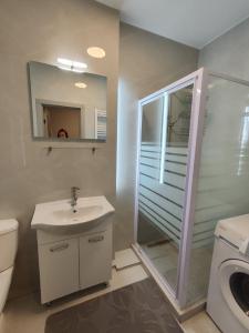 ein Bad mit einer Dusche, einem Waschbecken und einem WC in der Unterkunft Chisinau Central Apartments in Chişinău