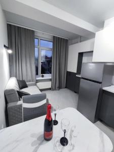 eine Küche und ein Wohnzimmer mit einer Flasche Wein auf dem Tisch in der Unterkunft Chisinau Central Apartments in Chişinău