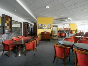 Hotel Cernigov في هراديك كرالوف: غرفة طعام مع طاولات وكراسي حمراء