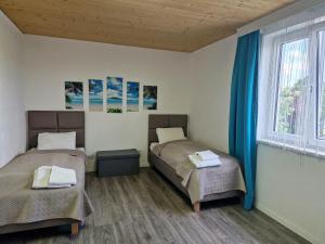 2 łóżka w pokoju z niebieskimi zasłonami w obiekcie Apartment St. Pölten w mieście Sankt Pölten