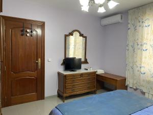 a bedroom with a bed and a dresser with a television at Villa Caniles in Caniles