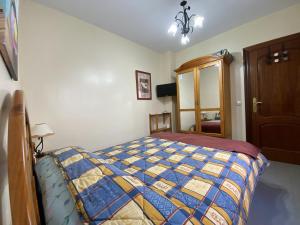 1 dormitorio con 1 cama con edredón azul y amarillo en Villa Caniles, en Caniles