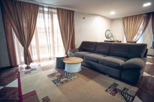 a living room with a couch and some windows at Apart4you Hotel in Chişinău