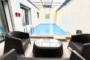 uma piscina com duas cadeiras e uma mesa e um ecrã em Luxury villa with private pool em Casablanca