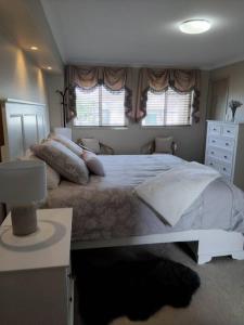 ein Schlafzimmer mit einem großen Bett und zwei Fenstern in der Unterkunft Mansion @ the Coast in Albion Park