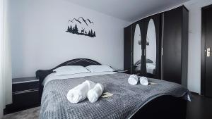 a bedroom with a bed with white shoes on it at CID APARTMENT CAVNIC in Cavnic
