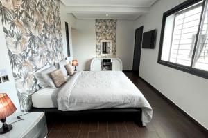 a bedroom with a large bed and a wall at Luxury villa with private pool in Casablanca