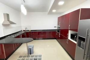 a kitchen with red cabinets and a table in it at Luxury villa with private pool in Casablanca