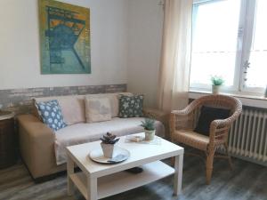 ein Wohnzimmer mit einem Sofa, einem Tisch und einem Stuhl in der Unterkunft Wohnung in Oberhausen mit Großem Garten in Oberhausen