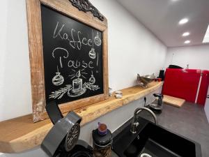 a chalkboard on the wall above a kitchen sink at Anderswo Bad Aibling in Bad Aibling