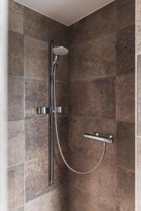 een douche met een douchekop in de badkamer bij Guesthouse Amfora in Poperinge