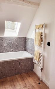 a bathroom with a bath tub and a window at Gîte au Haras d'Agathe et ses princes in Les Barils