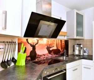 a kitchen with a counter with a painting of deer at Appartement in Saig mit Garten und Grill in Lenzkirch