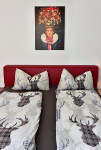 a bedroom with two beds and a picture on the wall at Appartement in Saig mit Garten und Grill in Lenzkirch