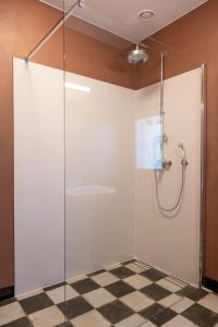 baño con cabina de ducha de cristal y suelo a cuadros en Huis Octaaf, en Heuvelland