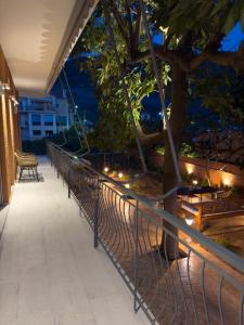 a row of benches next to a tree at night at Terpsichore's House in Sami