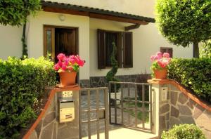een huis met potbloemen op het balkon bij Ferienhaus auf dem Bio-Bauernhof Poggio alla Cavalla in Lazzeretto