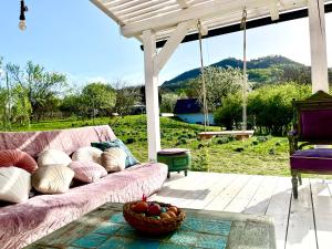 a pink couch on a porch with a basket of fruit at Arty House with huge terrace at lake Balaton in Kisapáti