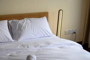 un letto bianco con lenzuola e cuscini bianchi di KLCC Luxury Private Pool Villa ad Ampang