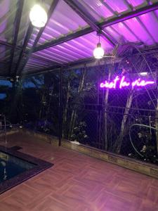 un patio avec des lumières violettes et une piscine dans l'établissement Imagine Harmony, à Lonavala