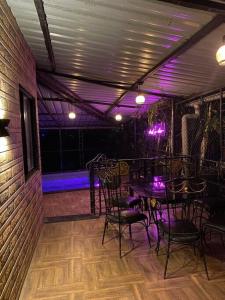 Zimmer mit Tischen, Stühlen und violetten Lichtern in der Unterkunft Imagine Harmony in Lonavla