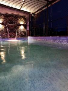 an empty swimming pool at night with lights at Imagine Harmony in Lonavala
