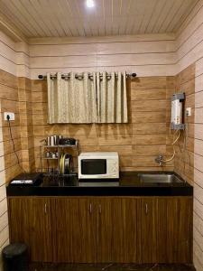 a kitchen with a counter with a microwave and a sink at Imagine Harmony in Lonavala